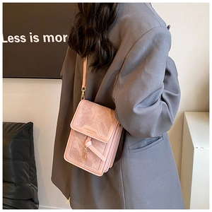Crossbody phone bag in matte pink leather with fashion lettering on a grey blazer