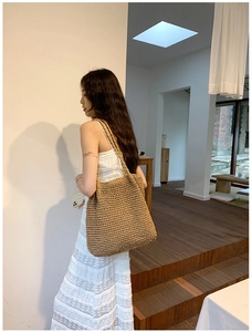 Close-up of a large woven straw tote bag featuring natural fibers and rustic texture