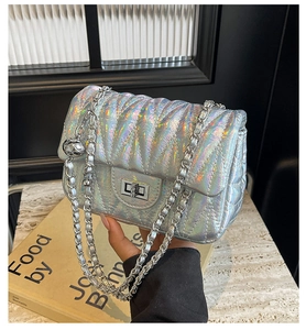 Détail du sac holographique argenté matelassé avec chaîne et boule métallique ronde