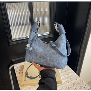 Detail of blue denim hobo bag with quilted diamond pattern and JINGPIN metal logo