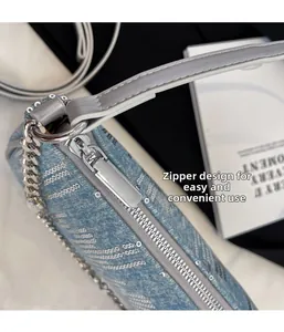 Detailed close-up of smooth metal zipper on blue denim shoulder bag with sequins