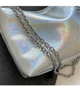Close-up of metallic silver laser PU leather handbag with chunky silver chain strap detail