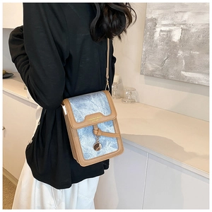 Detailed back view of a mini denim crossbody bag with brown leather trim and golden charms