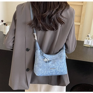 Detail of light blue denim dumpling bag with quilted texture and JINGPIN metal logo