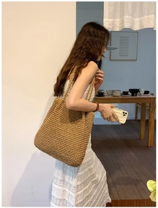 Detail of hand-woven straw tote bag with dense cross-stitch texture for summer