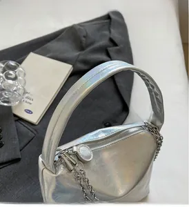 Detail of silver pleated pillow bag showing chain strap and metallic zipper closure