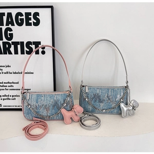 Detail of blue denim shoulder bag featuring gradient sequins and cute puppy pendant