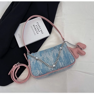 Detail of light blue denim underarm bag with pink leather trim and silver chain