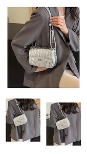 Détails du sac bandoulière argenté matelassé avec chaîne et finition métallique brillante
