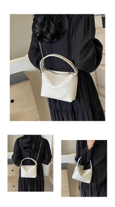 Close-up of cream glossy patent leather underarm bag with metal chain strap detail