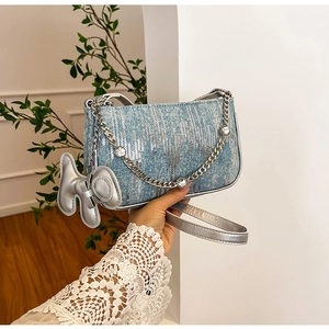 Close-up of blue denim sequin bag with silver chain, rhinestones and dog charm