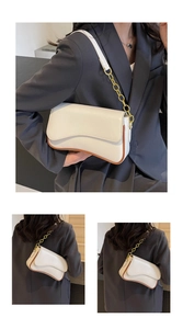 Makroansicht der wellenförmigen Klappe und Metallkette der cremeweißen Schultertasche