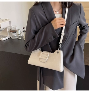 Detail of white crocodile embossed texture and square buckle on French baguette bag