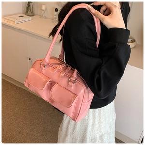 Detail view of pink glossy faux leather shoulder bag with decorative front pockets