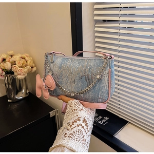 Detail of light blue sequin shoulder bag with pink leather trim and silver chain strap