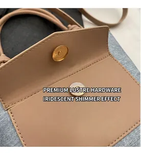 Détail du fermoir magnétique doré et des coutures sur le sac seau en cuir beige