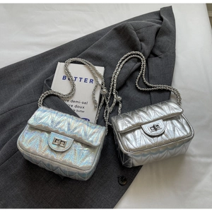 Détail d'un sac à rabat matelassé en argent iridescent et métallisé avec fermoir rotatif