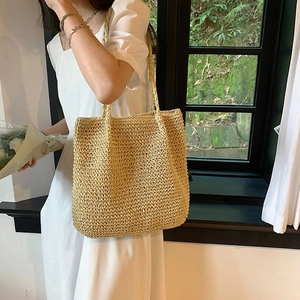 Large straw tote bag for women featuring natural woven texture and long shoulder handles