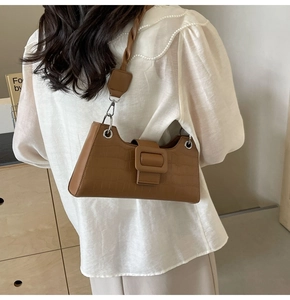 Detail shot of brown crocodile pattern baguette bag with stylish square buckle decor