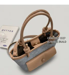 Détail du sac seau en denim bleu et cuir marron avec poignées nouées et poche avant