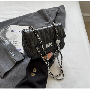 Détail du sac en cuir matelassé noir avec fermoir carré argenté et bandoulière chaîne
