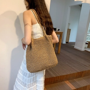Minimalist straw tote bag with large capacity shown being worn on a model's shoulder