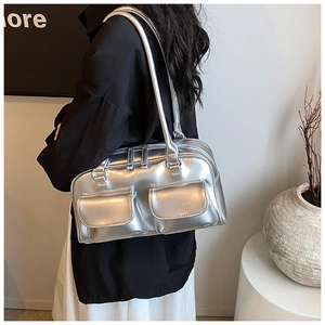 Detail of silver metallic shoulder bag featuring dual flap pockets and large capacity