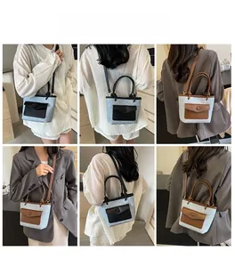 Sac seau en feutre gris avec garniture en cuir porté en bandoulière et à la main