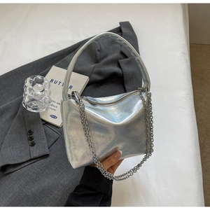 Close-up of holographic silver handbag with sleek metallic finish and decorative chain detail