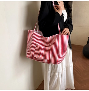Detail of red and white striped canvas tote bag showing the front pocket and texture