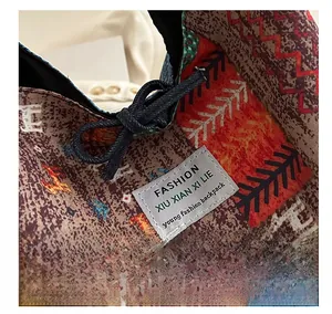Makro-Detail von geometrischem Jacquard-Stoff und Kunstlederetikett an einer Boho-Tasche