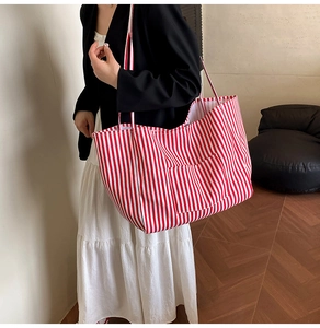Detailed close-up of striped canvas tote bag with outer pocket and red white patterns