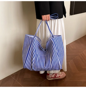 Detail view of large canvas tote bag with classic blue and white vertical stripes