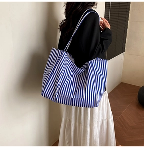 Detailed view of striped canvas tote bag showing the texture and side pocket design