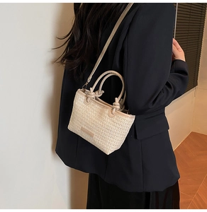 Vue détaillée du sac à main en paille tressée avec poignée en cuir nouée et bandoulière