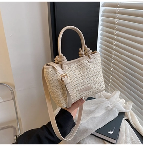 Détail du sac en paille tressé avec poignée à nœud décoratif et bandoulière réglable