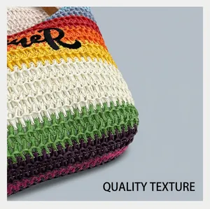 Détail de la texture tissée colorée et broderie noire sur ce sac de plage d'été