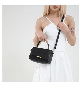 Vue détaillée d'un petit sac carré noir en cuir avec fermoir doré élégant