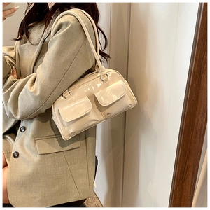 Chic off-white patent leather shoulder bag with vintage dual pockets on model