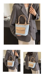 Détails du sac seau bleu clair avec cuir marron et poche frontale à bouton-pression