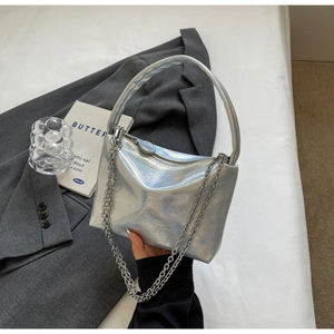Detail view of silver holographic underarm bag with pleated texture and metal chain