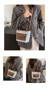 Vue détaillée du sac seau en tweed bleu clair avec finitions et anses en cuir marron