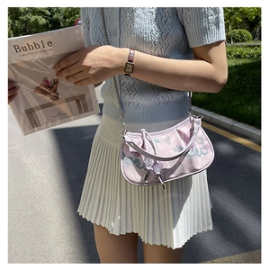 Close-up of light purple floral embroidery on mini square shoulder bag with metal chain
