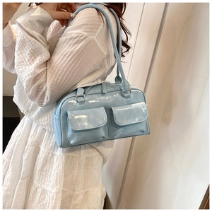 Detail showing the light blue patent leather shoulder bag with two front pockets