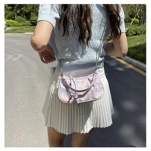 Detailed shot of lavender floral embroidery and silver chain strap on a small handbag