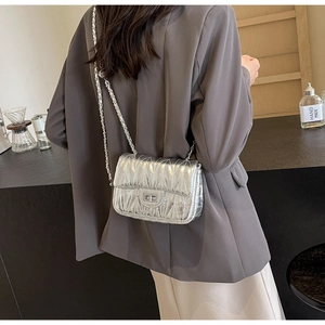 Sac à bandoulière argenté matelassé avec chaîne porté par un mannequin de vue arrière