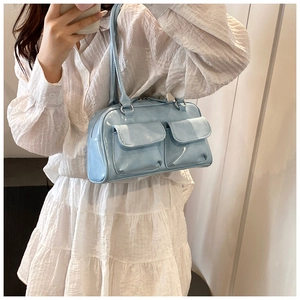 Detail showing the light blue PU leather shoulder bag with two front pockets on a model