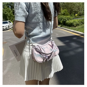 Outdoor street shot of a lilac floral handbag with metal chain and bow detail