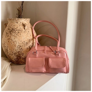 Detailed macro view of glossy pink bowling bag with silver metal buckles and pockets