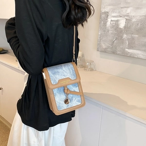 Vintage denim and brown leather crossbody bag shown on a model in a modern room